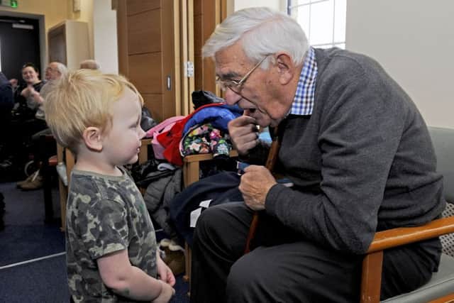 A little boy shares a story with an elderly gentleman