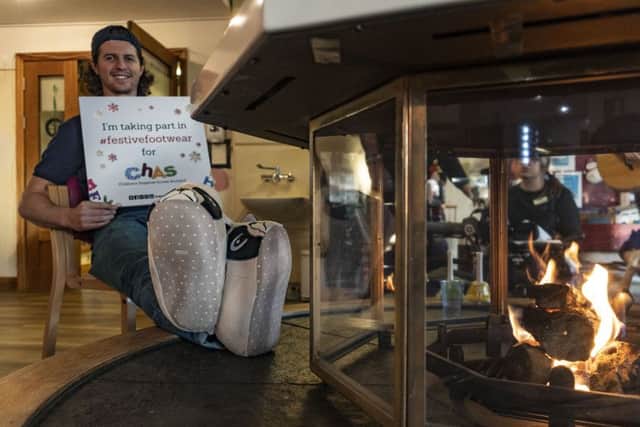 Putting his feet up...Fife Flyers player Paul Crowder is supporting Children's Hospices Across Scotland's Festive Footwear Friday Christmas fundraising drive tomorrow. He is pictured here at Rachel house, donning his festive baffies to help launch the campaign.