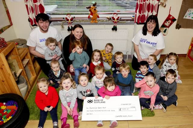 Staff and children from Cherrytree Nursery in Polmont present cheque to Scottish Cot Death Charity representatives