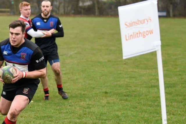 Linlithgow Rugby Club's Ross Plenderleith scores a try next to the corner flag sponsored by Sainsbury's