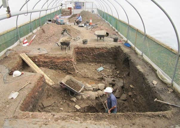 Digging in a polytunnel in 34 degree heat, the medieval ditch is revealed along with the 16th century path, just behind the man in the hardhat in the foreground.