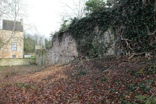 The west wall of the walled garden with the engaged pilaster at the end and Kinneil House beyond, showing the change in slope.