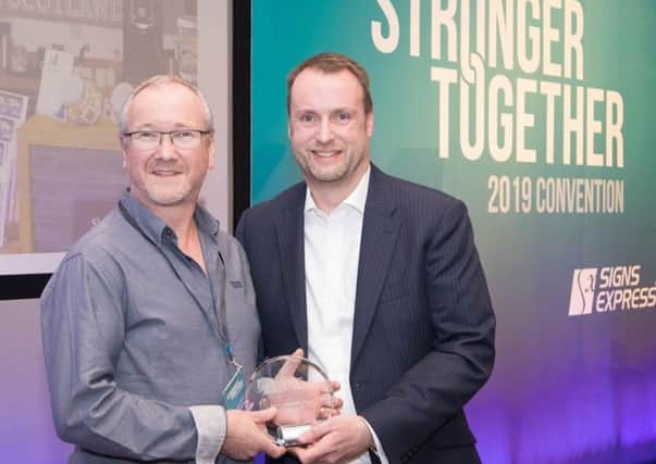 Signs Express (Falkirk) owner Steve McMurray, left, receives his award from group managing director Jonathan Bean.