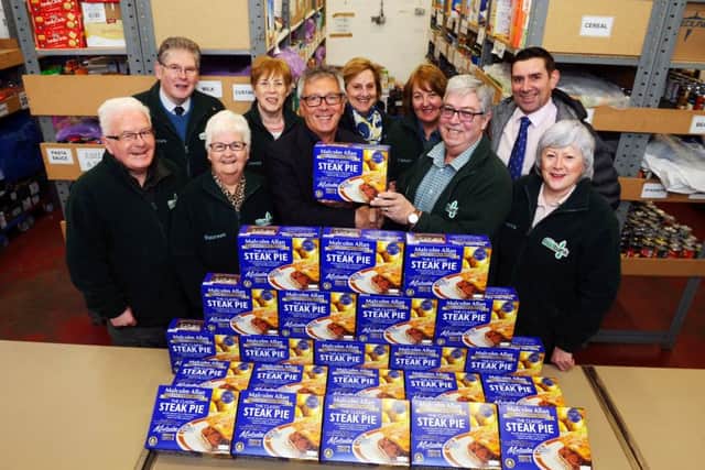 Gordon Allan (front, third from left) shakes hands with Falkirk Foodbank chairman Alastair Blackstock. Pictures: Michael Gillen
