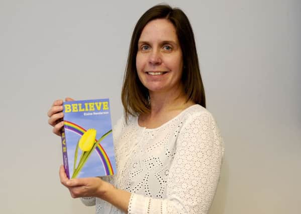 Elaine Henderson with her book, Believe, about her life in foster care and search to find her mum