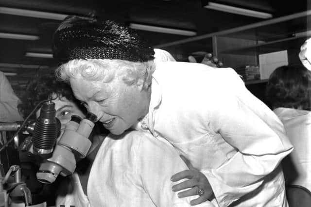 Veteran singer and actress Gracie Fields looks down a microscope at an electronics factory in Falkirk in November 1970.