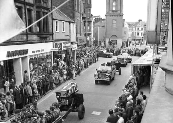 Pedestrians stop in silent tribute as the coffins of two part-time paratroopers killed in the River Trent disaster are carried through Falkirk High Street in October 1975. 10 members of the 131 Independent Squadron TA regiment were killed at Cromwell Weir in Nottinghamshire.