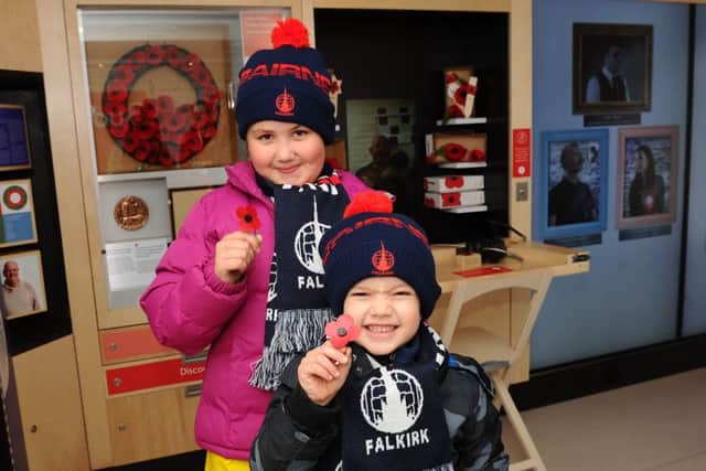 Big fans...of not only Falkirk FC but also of Poppyscotland's new Bud are Millie Whyte (8) and her wee brother Robbie (5) from Denny with their own hand-made poppies. (Pic: Michael Gillen)