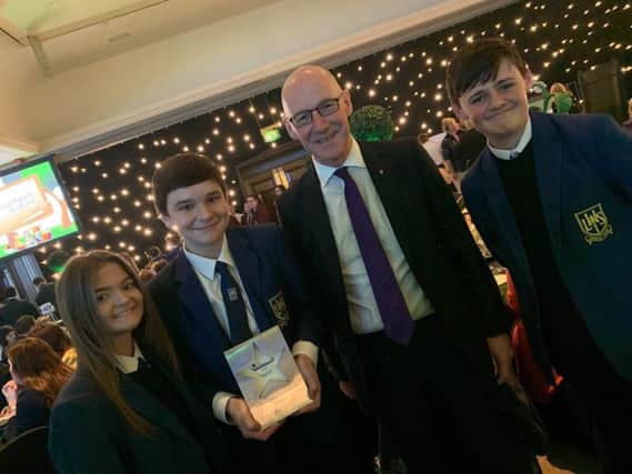 Cabinet Secretary for Education John Swinney with pupils at Larbert High School holding their 'Parents as Partners in Learning' Scottish Education award