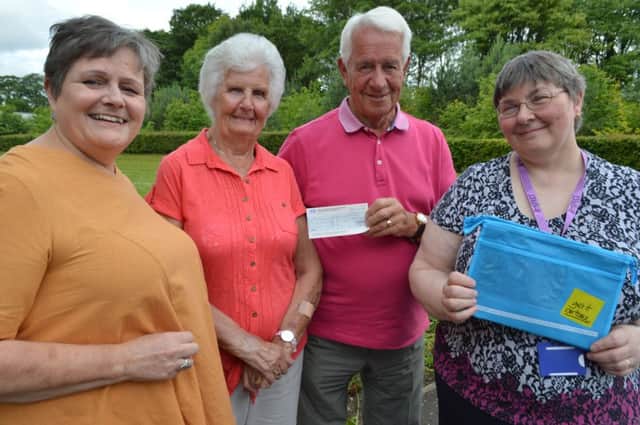 Jim and Nessie Cowie, with daughter Jacqueline Lyons (left), hand over the £400 cheque to Parkinsons nurse specialist Kay Mair