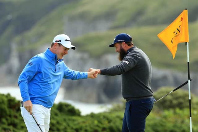 Andrew Johnston of England high fives Robert MacIntyre of Scotland on the 5th green during the first round of the 148th Open Championship  (Photo by Mike Ehrmann/Getty Images)