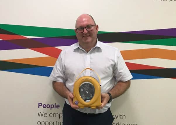 James Donaldson and Son integrated systems manager Mark Murphy with one of the automated external defibrillators.