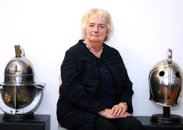 Author Lindsey Davis, pictured with reconstructions of the sort of helmets once worn by gladiators.