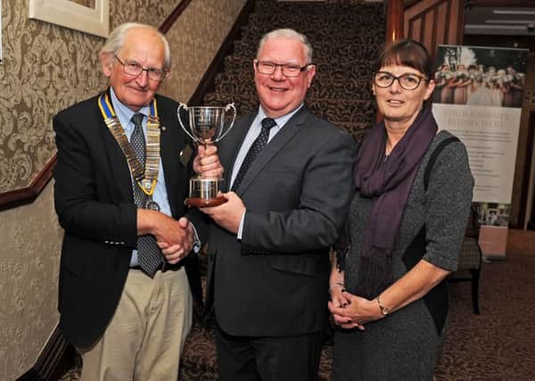 Neil Edwards (centre) is pictured with wife Maureen as he receives the Community Service Award from Rotary Club of Polmont president Jim Dyer. Picture: Michael Gillen