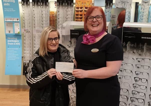 Customer Nicole Cook, left, receives her prize from store manager Laura Owens.