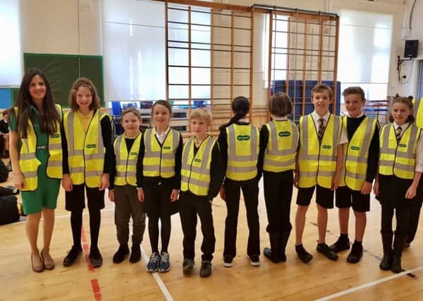 Low Port Primary School pupils wearing Specsavers high vis vests alongside acting principal teacher Natalie McCartney.